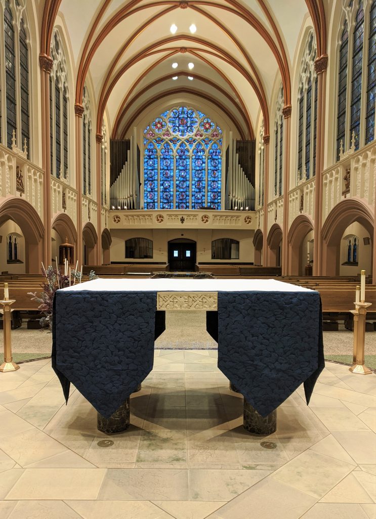 The altar with a blue altar cloth over it.