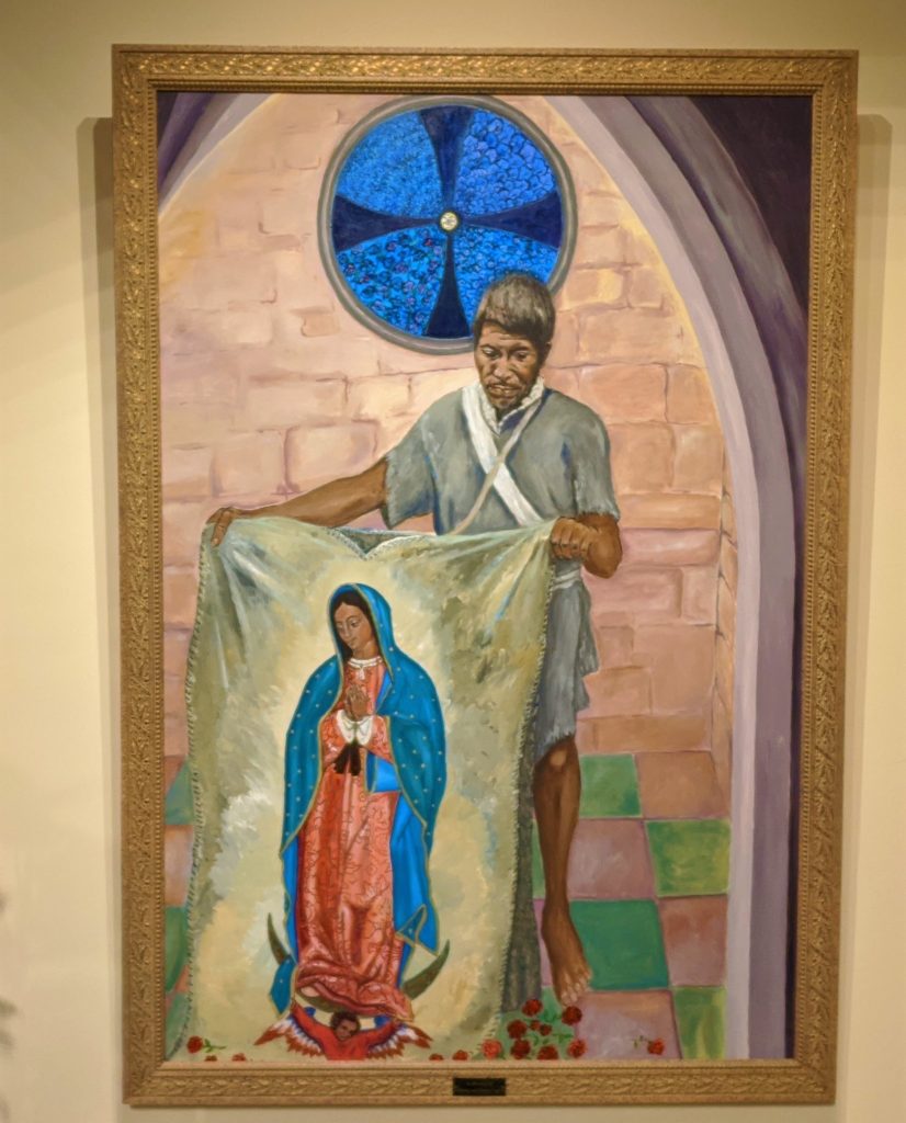 A large painting of Saint Juan Diego showing the tilma with the image of Our Lady Guadalupe on it.